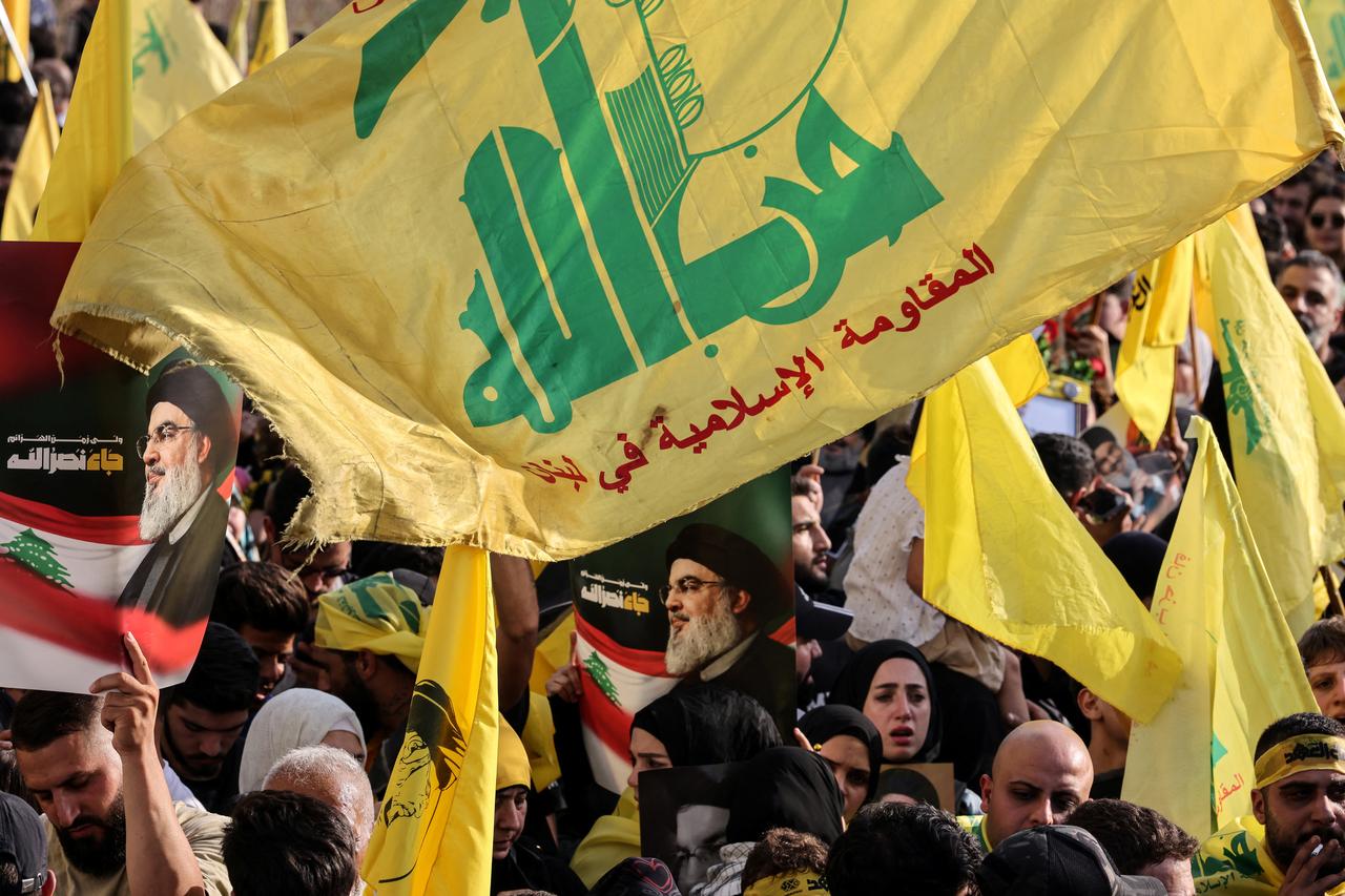 Hezbollah supporters raise the party's yellow flags and pictures of its slain leader, as they mark the first anniversary of his killing, in Beirut's seaside Raouche area, on September 25, 2025. (AFP Photo)