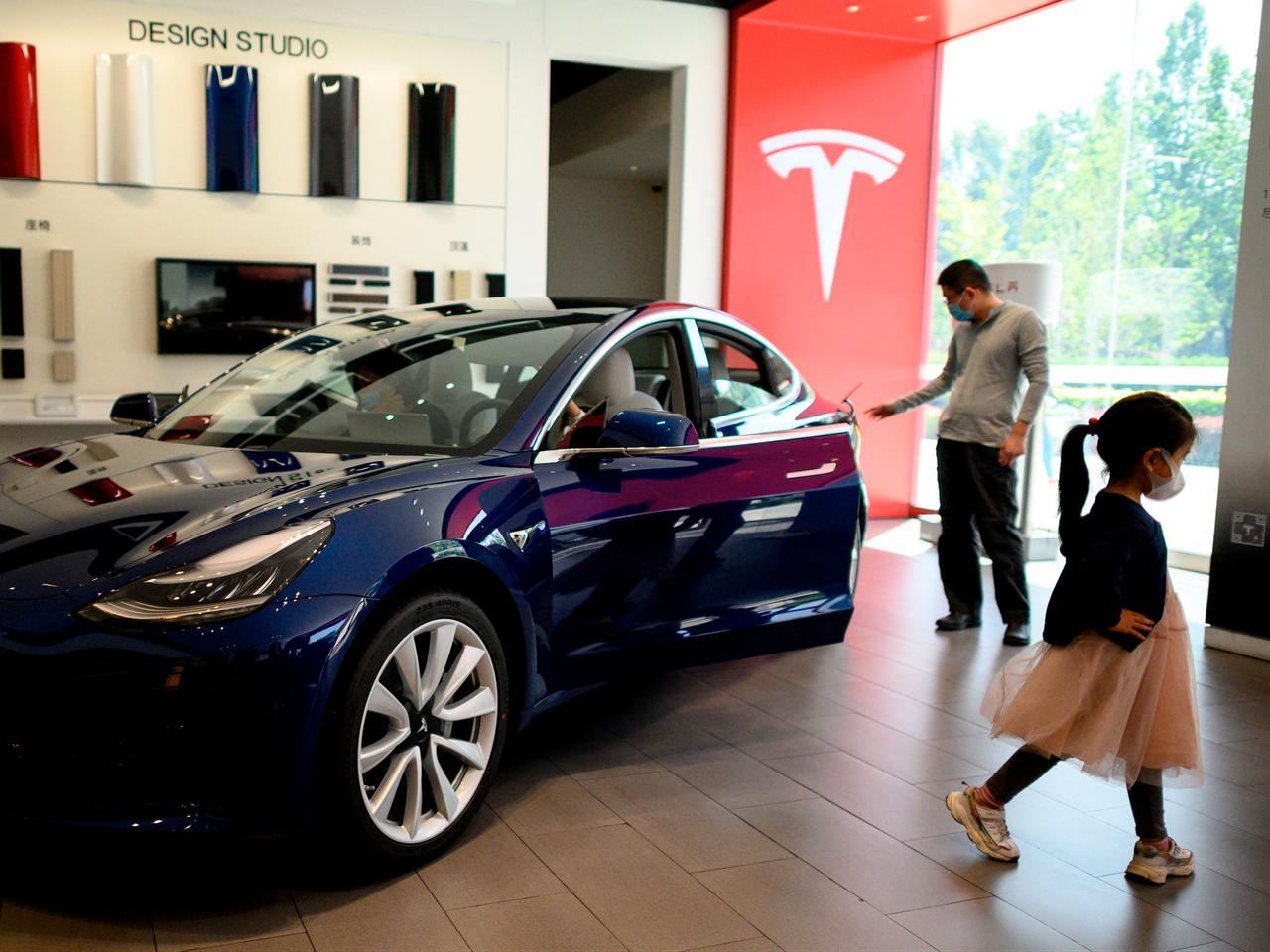 People looking at a Tesla car on display at a showroom in Beijing, China, on May 10, 2020. (AFP Photo)