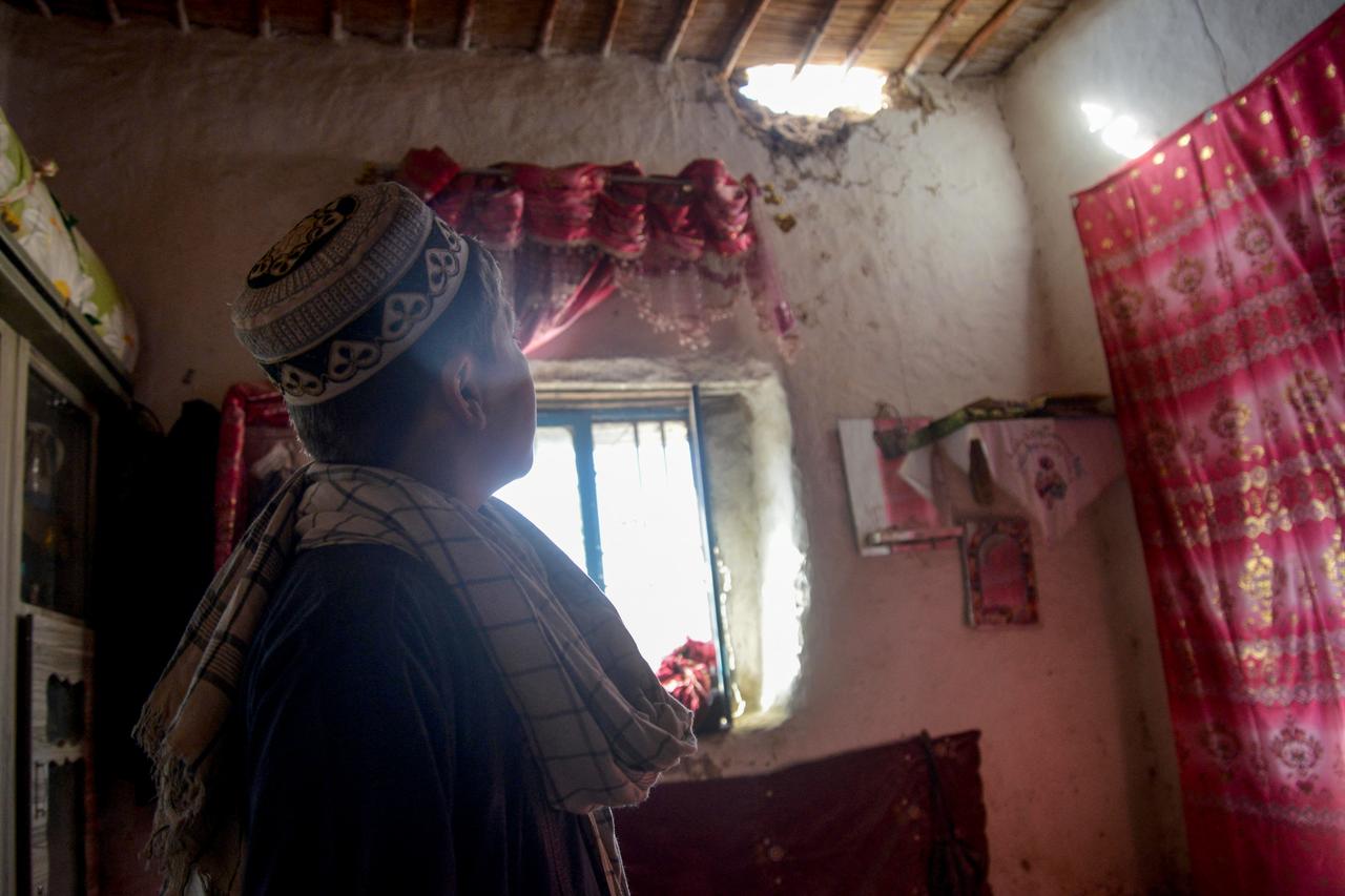 Afgan bir adam, 7 Kasım 2025'te Kandahar'ın Spin Boldak bölgesindeki bir köyde Pakistan'ın topçu bombardımanı nedeniyle sınır ötesi açılan ateş sonrasında hasar gören bir evi inceliyor. (AFP Fotoğrafı)