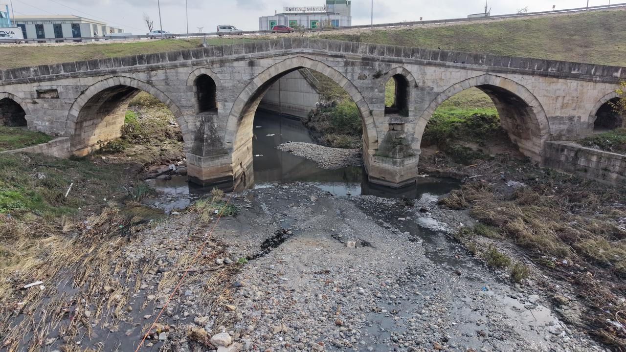 The 16th-century Haramidere (Kapi Agasi) Bridge, attributed to Mimar Sinan, sits abandoned beneath the E-5 Highway in Istanbul’s Beylikduzu district, Türkiye, Oct. 8, 2025. (IHA Photo)
