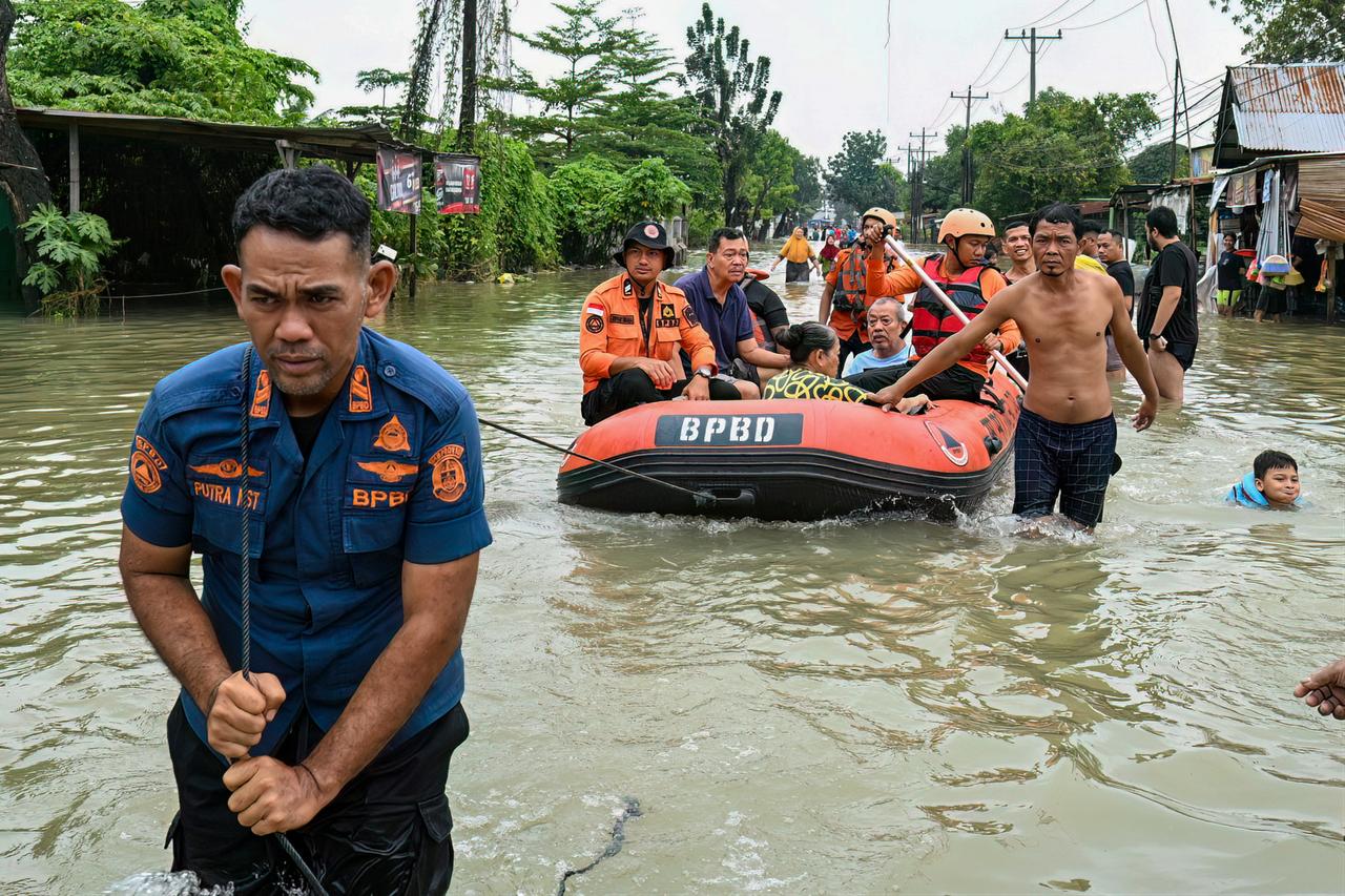 Rescue teams transport an elderly person by rubber boat amid the flooding. Medan, Indonesia, November 28, 2025. (Photo by YT Hariono / AFP)