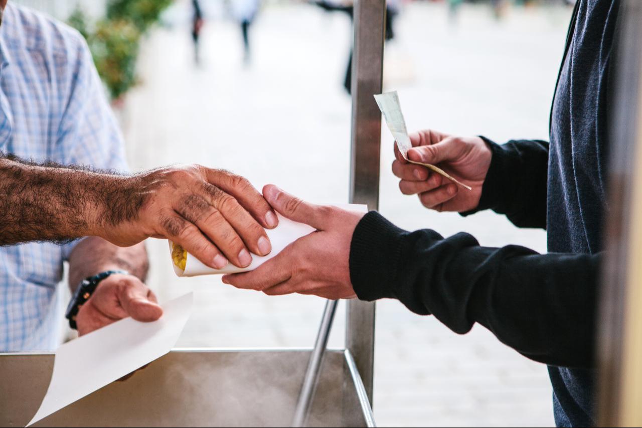 A street vendor sells cooked corn to a customer in Istanbul, Türkiye. (Adobe Stock Photo)