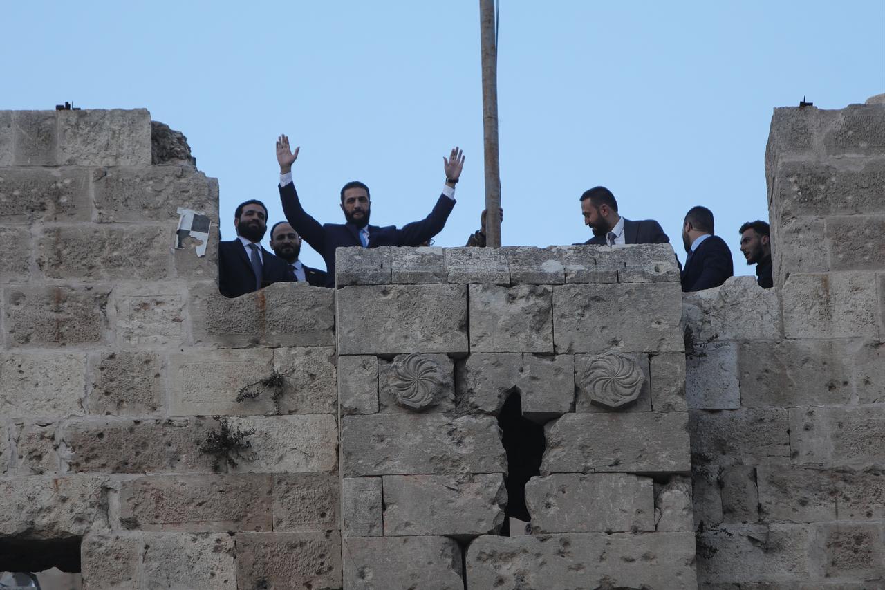 Syrian President Ahmed al-Sharaa waves to the crowd at the gate of Aleppo’s Citadel during celebrations marking one year since an Islamist alliance, led by Sharaa, entered the northern city and swiftly took control of it, on November 29, 2025. (AFP Photo)