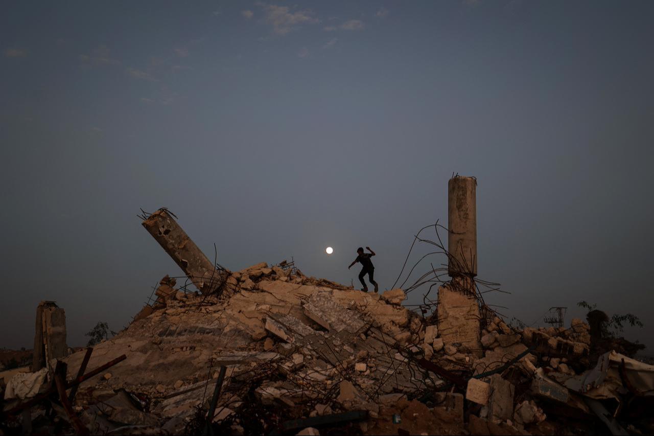 A youth plays on the rubble of a destroyed building as the Cold Moon, rises over the Nuseirat camp for displaced Palestinians in the central Gaza Strip, Dec. 4, 2025. (AFP Photo)