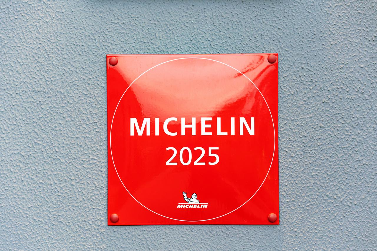 A restaurant displays its bright red Michelin 2025 plaque on an exterior wall. (Adobe Stock Photo)
