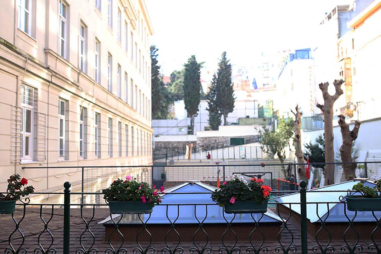 A view of the terrace and courtyard of the Private Italian High School, with flower boxes in the foreground and the school building rising alongside the slope. (Photo via Liceo Italiano IMI official website)