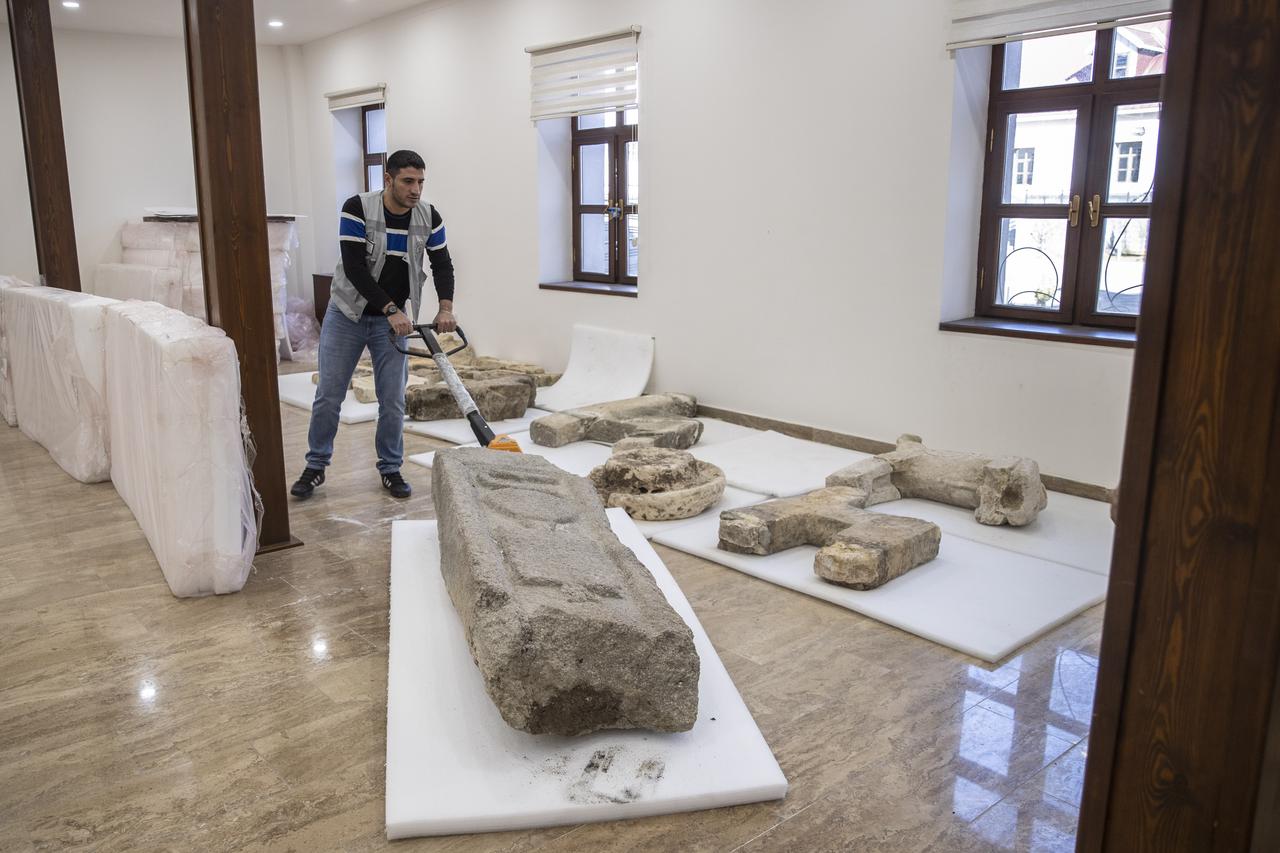 A staff member transports a large grave-chest fragment inside Tunceli Museum after its recovery from Pertek Fortress following the recession of Keban Dam Lake in Tunceli, Türkiye, Dec. 11, 2025. (AA Photo)