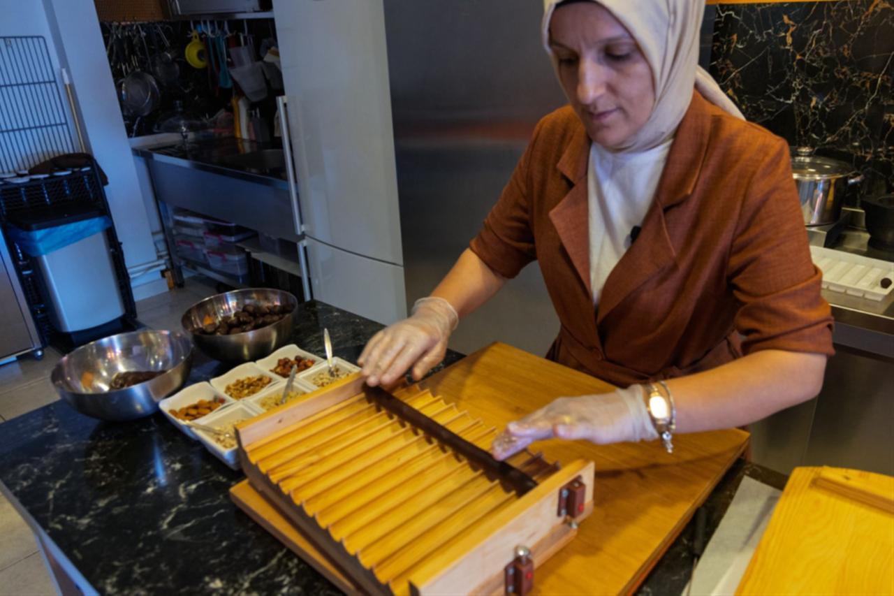 Ayten Yavuz prepares handmade chocolates using a wooden mould in the workshop, Ankara, Türkiye, December 11, 2025. (Courtesy of European Union)