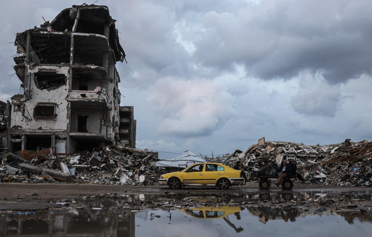 A man drives a yellow car next to a pool of water in the Al-Saftawi neighborhood, west of Jabalia city in the northern Gaza Strip, Dec. 10, 2025. (AFP Photo)