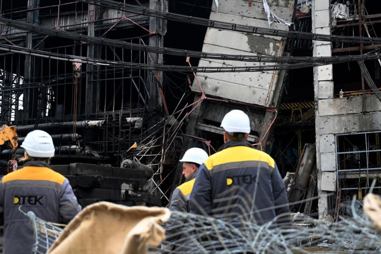Employees stand next to the building of a power plant of Ukrainian energy provider DTEK, which was heavily damaged during air attacks in Ukraine, December 10, 2025. (AFP Photo)