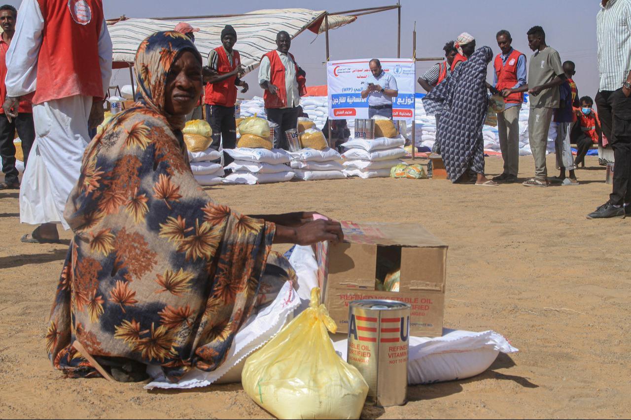 A Sudanese woman who fled El-Fasher sits next aid she received at the Al-Afad camp for displaced people in the town of Al-Dabba, northern Sudan, on Nov. 25, 2025 ( AFP Photo )