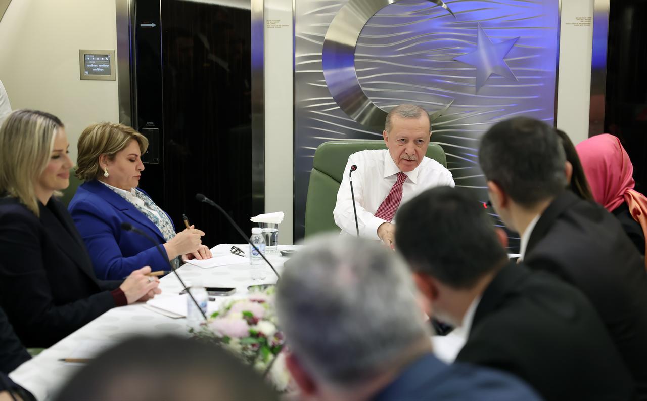 Turkish President Recep Tayyip Erdogan (C) makes statements to journalists aboard the plane on his return from Ashgabat, Turkmenistan, following International Peace and Security Forum, in Ankara, Türkiye, on Dec. 12, 2025. (AA Photo)