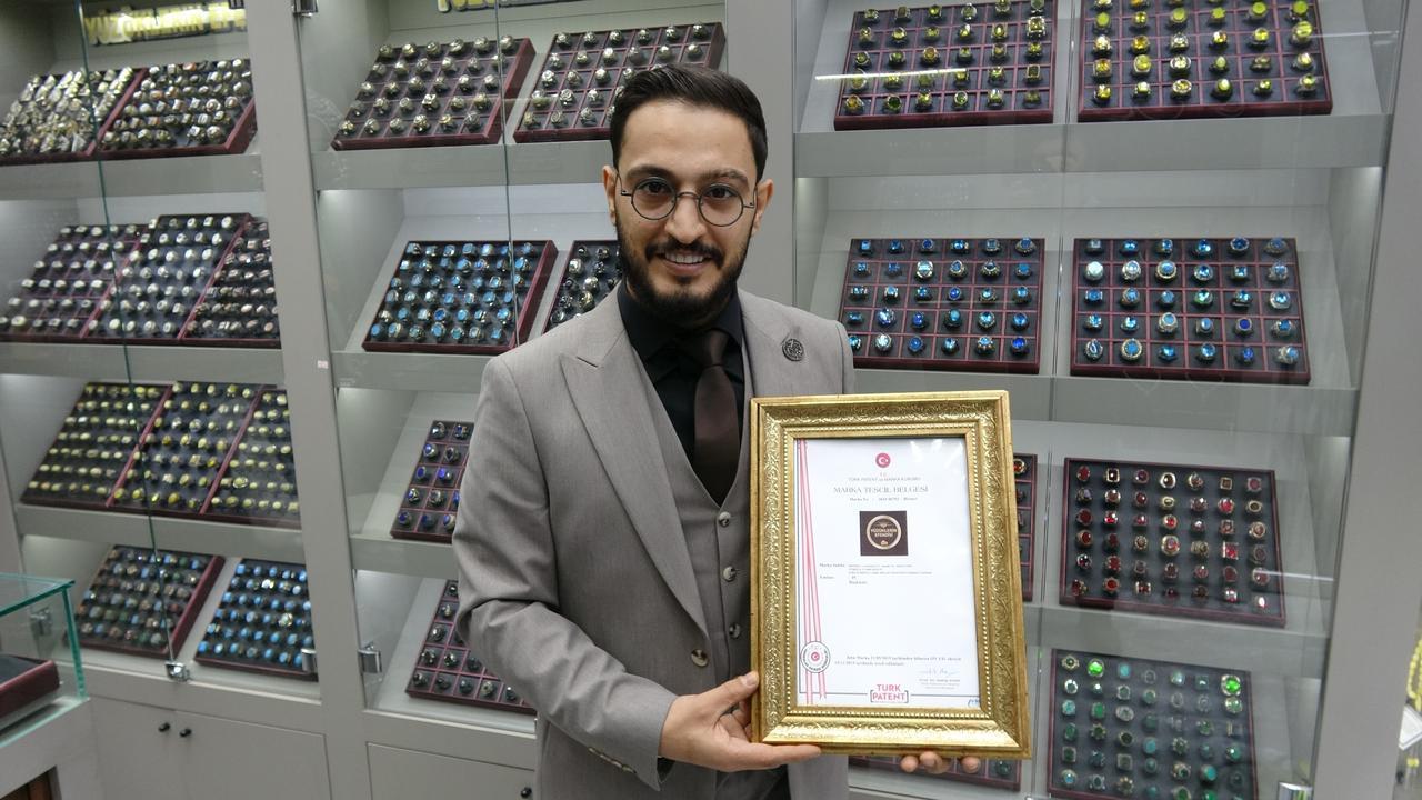 Mehmet Cakmak, a silver ring maker based in Türkiye’s Gaziantep, holds his trademark registration certificate for “Yuzuklerin Efendisi (Lord of the Rings)” inside his jewelry shop in Gaziantep, Türkiye, December 14, 2025. (IHA Photo)