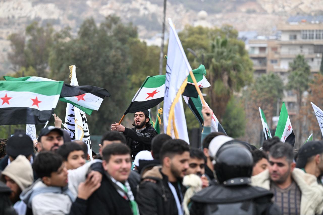 People wave Syrian flags as they celebrate a year since the ousting of longtime ruler Bashar al-Assad in Damascus, Syria on Dec 8, 2025. (AFP Photo)