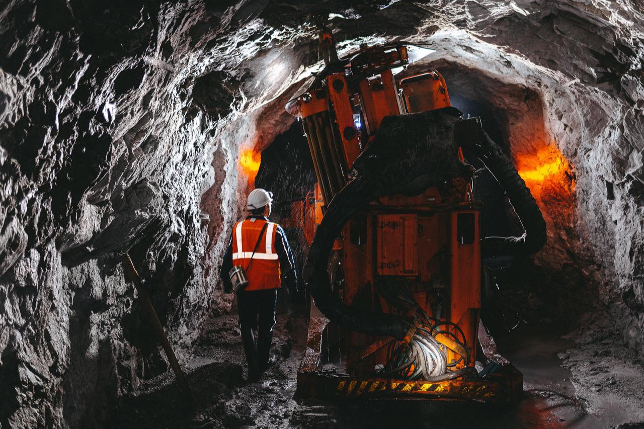 A mining engineer inspects underground drilling equipment inside a mineral extraction tunnel. (Adobe Stock Photo)