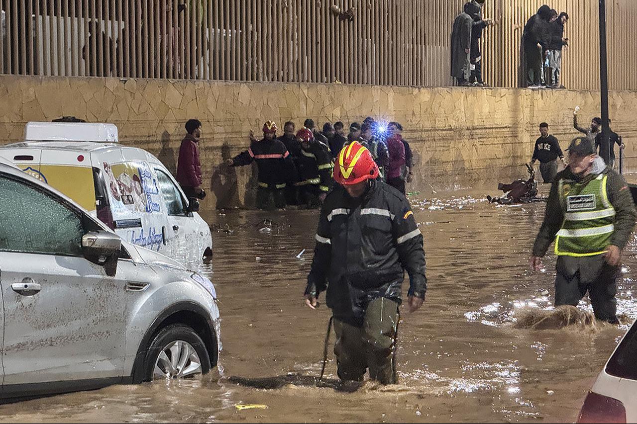 People wade through a square after a flash flood in Safi on December 14, 2025.  ( AFP Photo )