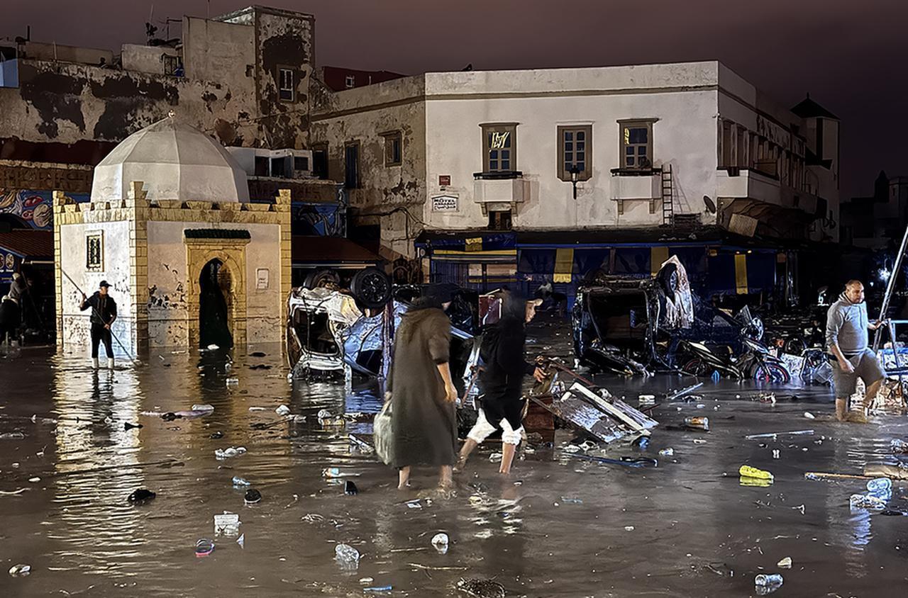 People wade through a square after a flash flood in Safi on December 14, 2025.  ( AFP Photo )