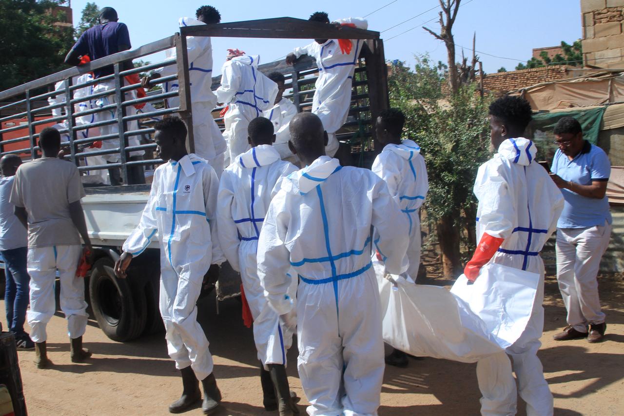 Employees working for the authorities load a body bag into the back of a lorry as bodies are dug up from an emergency burial site inside a school in Khartoum, Sudan on Dec. 8, 2025. (AFP Photo)