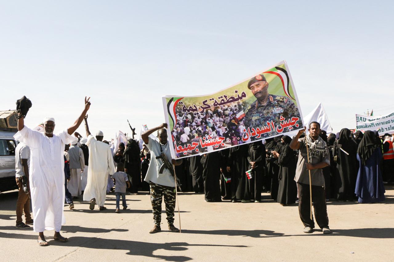 Sudanese men hold up a banner that showing an image of Sudanese regular army chief Abdel Fattah al-Burhan, as they take to the streets during a rally in support of the Sudanese Army, in Khartoum, Sudan on Dec. 13, 2025. (AFP Photo)