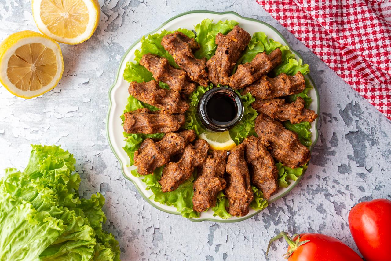 Cig kofte (raw meatball in Turkish) served with lettuce. (Adobe Stock Photo)
