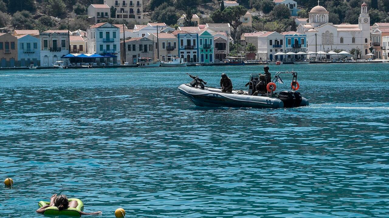 A person enjoys the sea as a Greek army rib returns from patrol on the tiny island of Meis, in the Dodecanese, the furthest south-eastern island, on August 28, 2020. (AFP Photo)