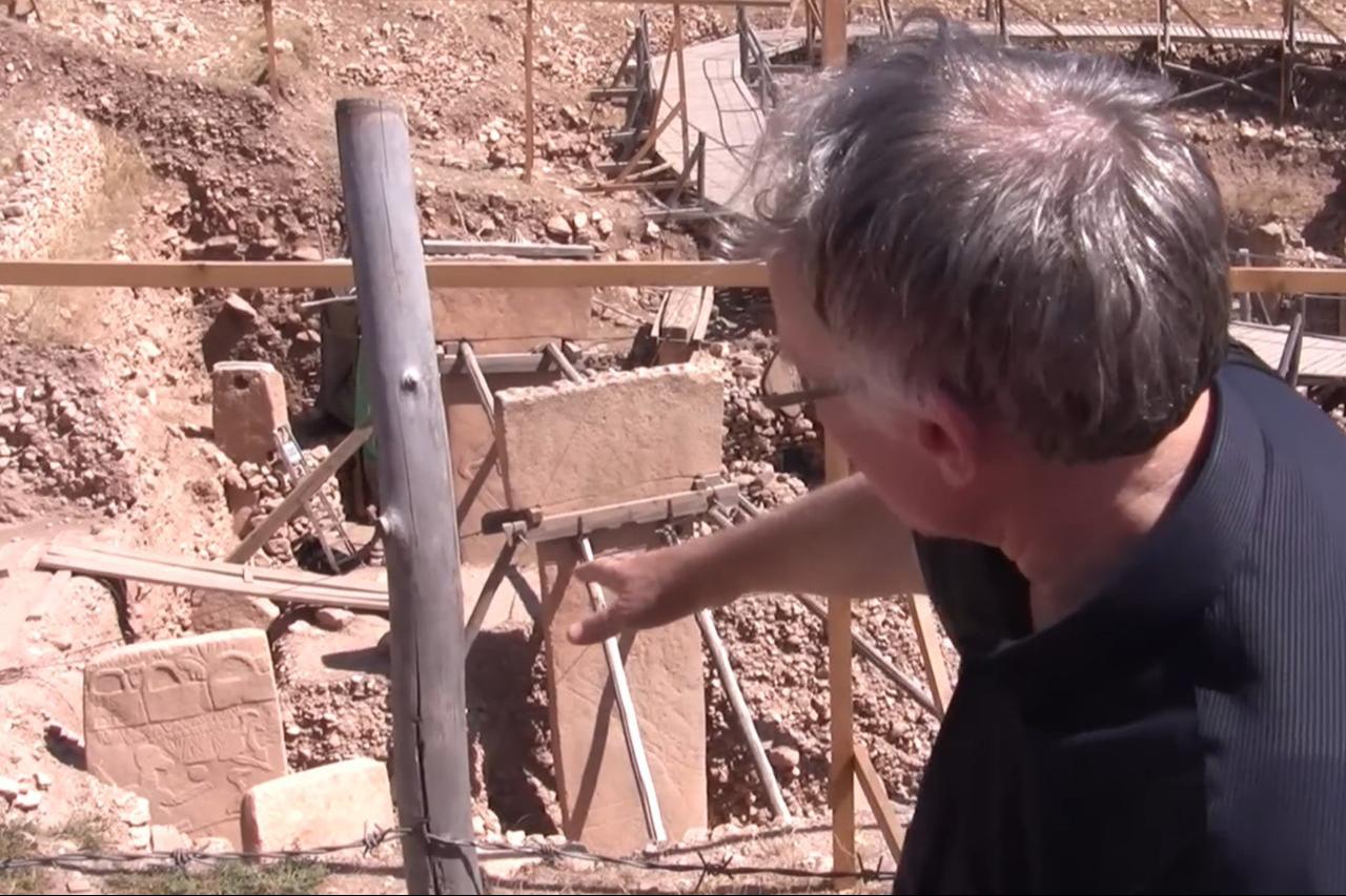 Graham Hancock shows Pillar 43, Gobeklitepe, Sanliurfa, Türkiye, Oct 10. 2013. (Photo via Youtube)