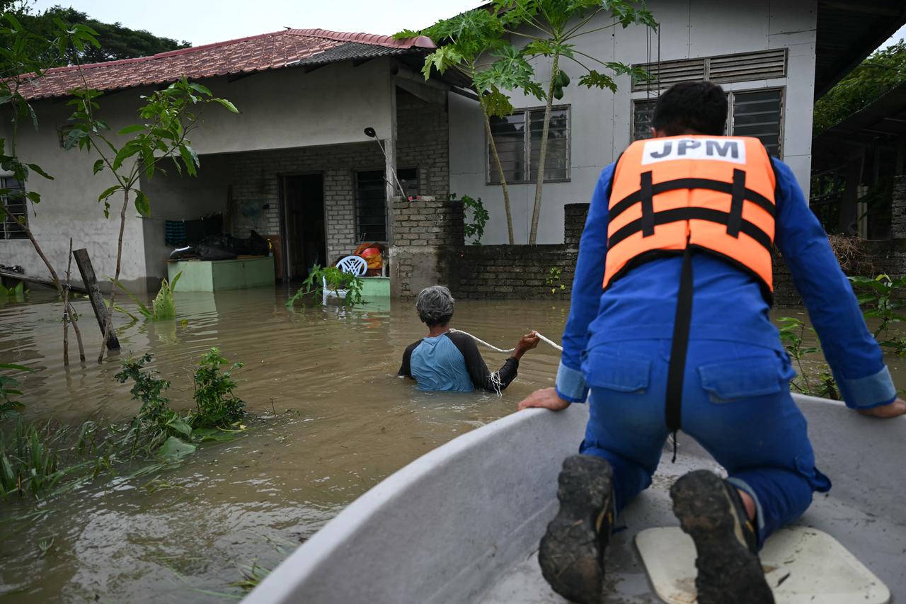 A rescue worker looks out from a boat as his team arrives a flooded house in Kangar, Perlis, Malaysia, November 27, 2025. (AFP Photo)