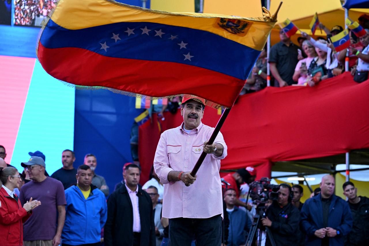 Venezuela's President Nicolas Maduro waves a national flag during a rally in Caracas on Dec. 1, 2025. (AFP Photo)