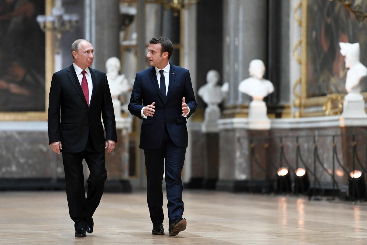 France's President Emmanuel Macron (R) speaks to Russia's President Vladimir Putin (L) in the Galerie des Batailles (Gallery of Battles) as they arrive for a joint press conference following their meeting at the Versailles Palace, near Paris, on May 29, 2017. (AFP File Photo)