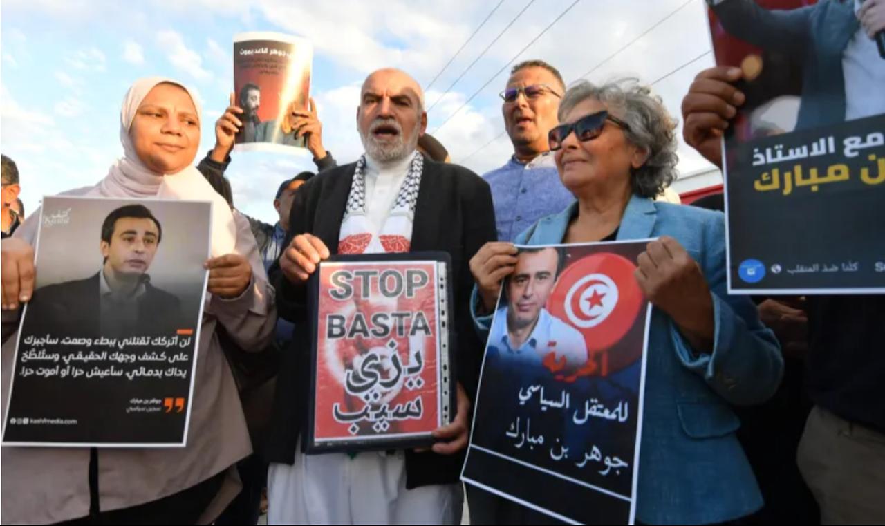 Tunisian human rights activist and journalist Sihem Bensedrine holds a portrait of jailed Tunisian opposition figure Jawhar Ben Mbarek during a protest outside the Billi prison in Nabeul on November 7, 2025. (AFP Photo)