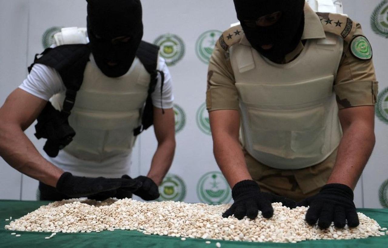 Officers of the Directorate of Narcotics Control of Saudi Arabia's Interior Ministry sort through tablets of captagon (Fenethylline) seized during a special operation and presented before AFP afterwards in the Red Sea coastal city of Jeddah on March 1, 2022. (AFP Photo )