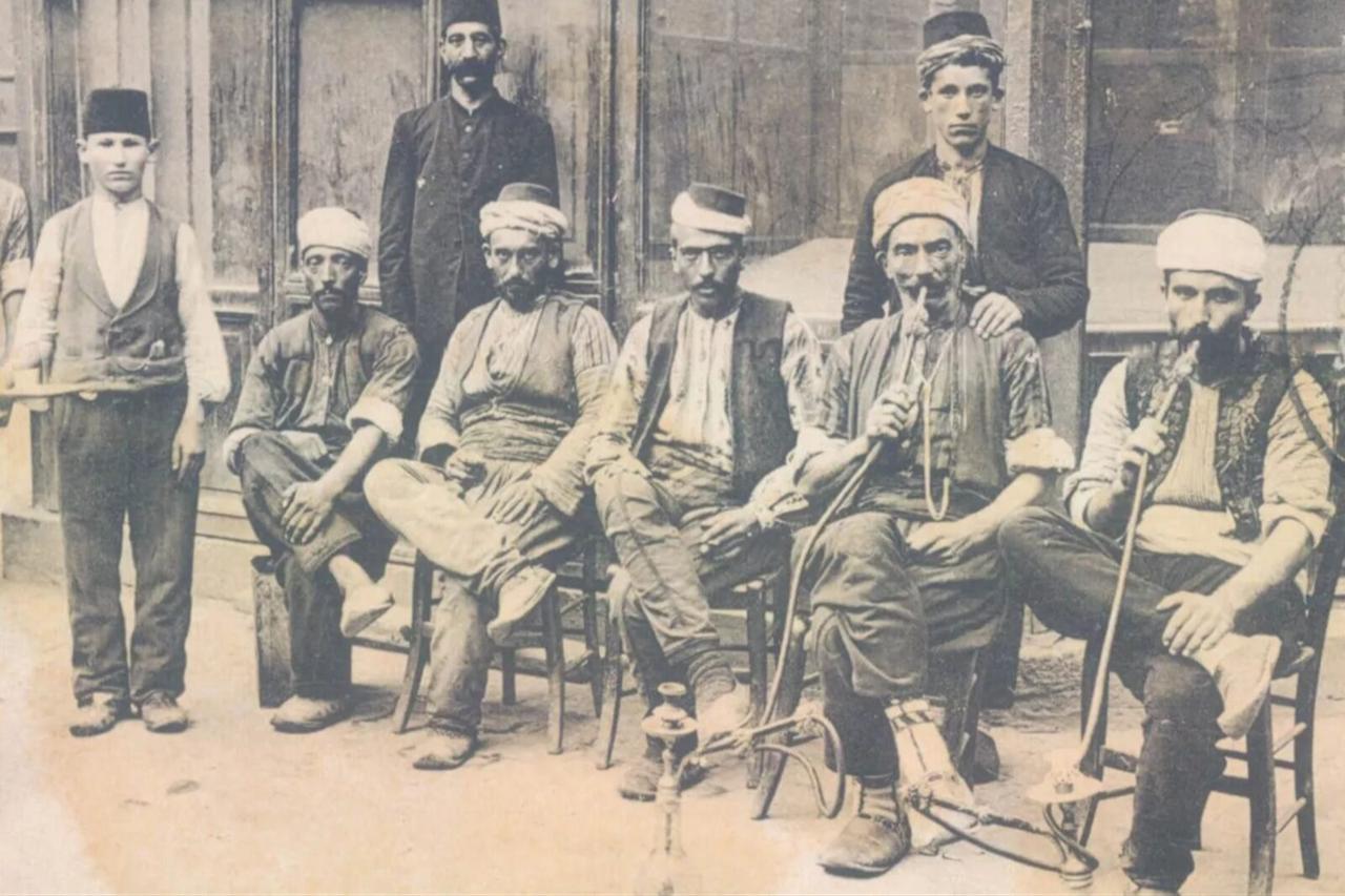 Porters smoking hookah in front of a coffeehouse, Trabzon, Türkiye, 1900s. (Photo via Istanbul Muzayede)