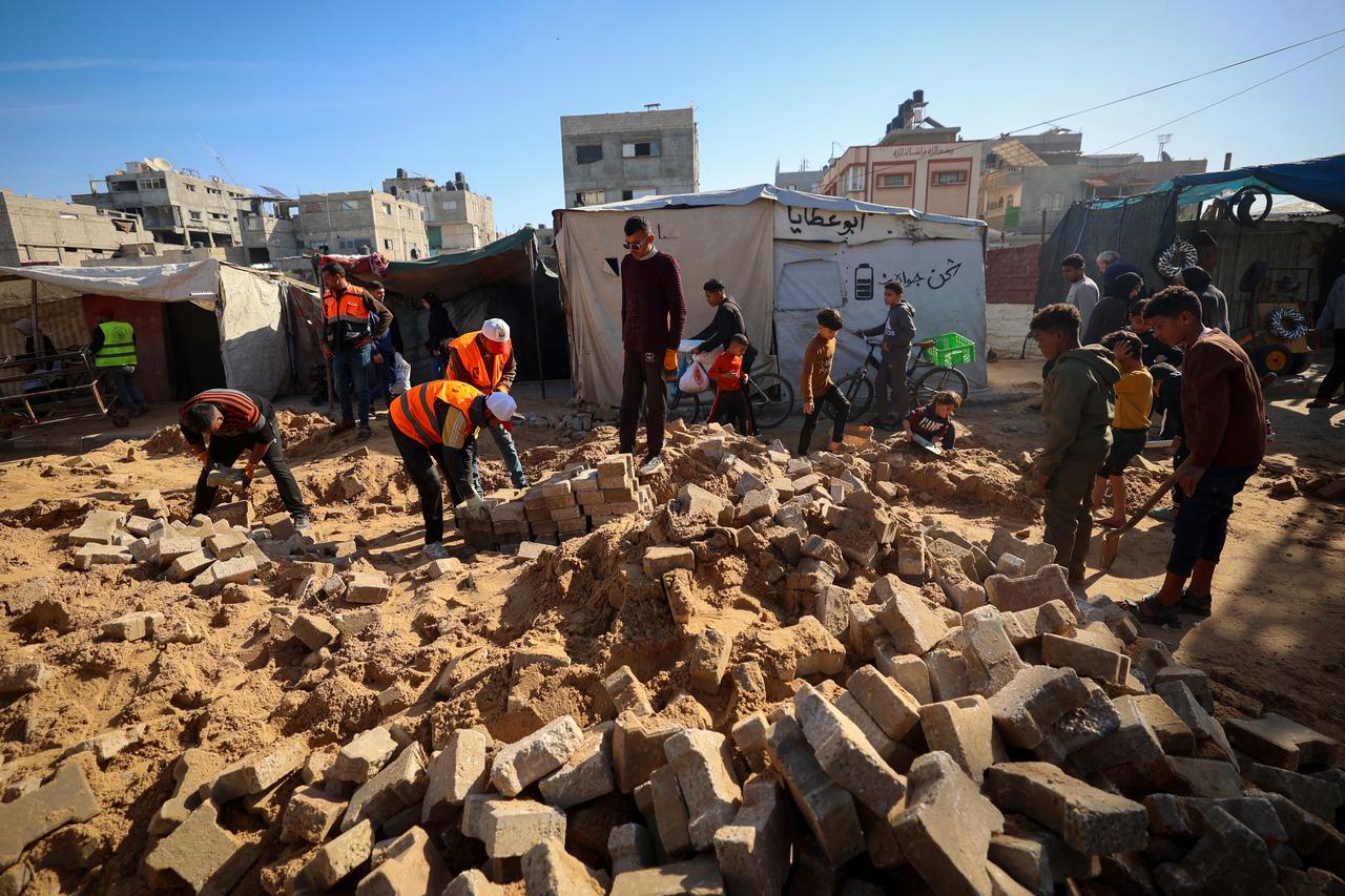 Palestinian municipality workers repair a road damaged during the war in the Nuseirat camp for the displaced in the central Gaza Strip on Dec. 22, 2025. (AFP Photo)