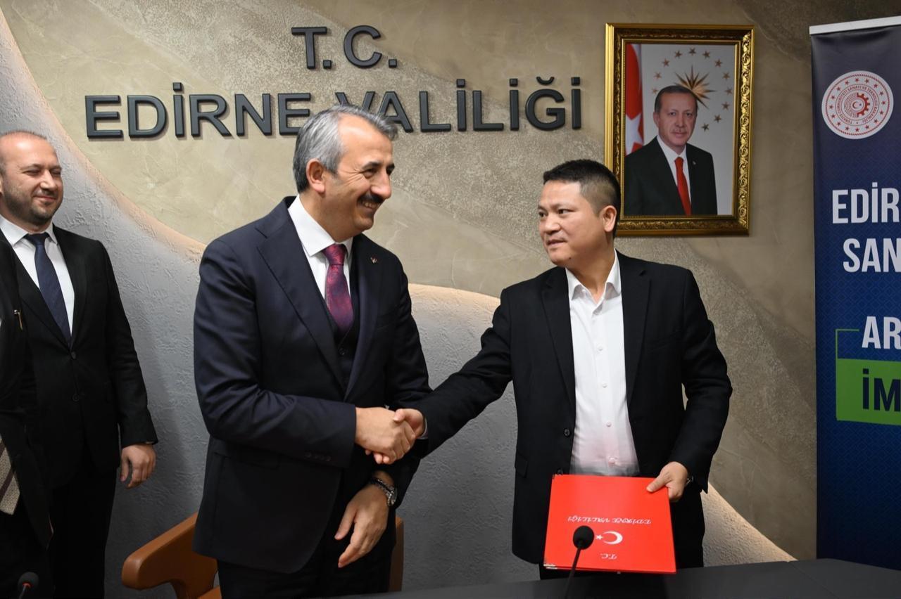 Edirne Governor Yunus Sezer (L) shakes hands with a representative of ZS Turkey Automotive Spare Parts Limited Company during the signing ceremony in Edirne, Türkiye, December 24, 2025. (AA Photo)