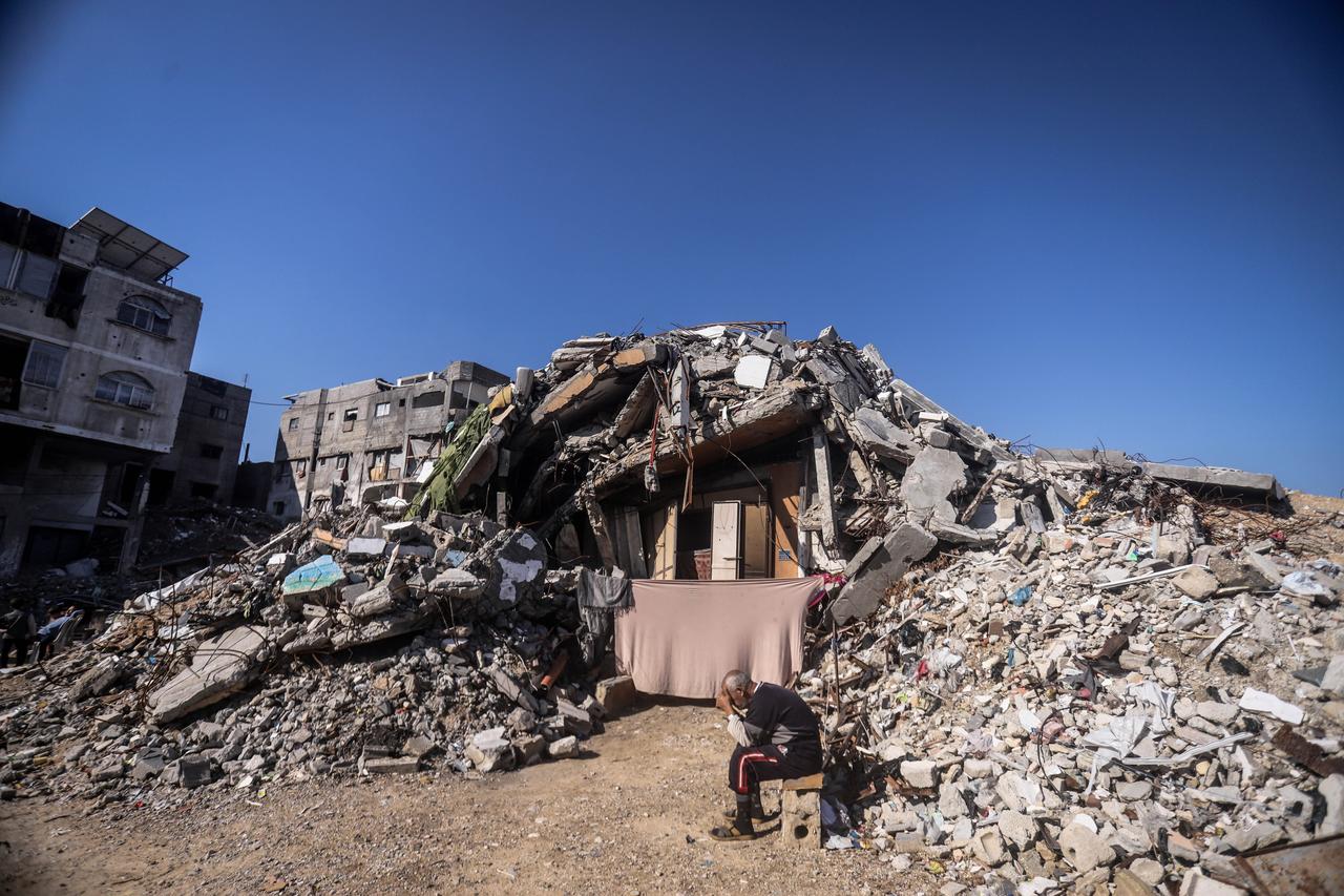 A person is seen in front of a collapsed building as displaced Palestinians are struggling to maintain their daily lives, Gaza, December 24, 2025. (AA Photo)