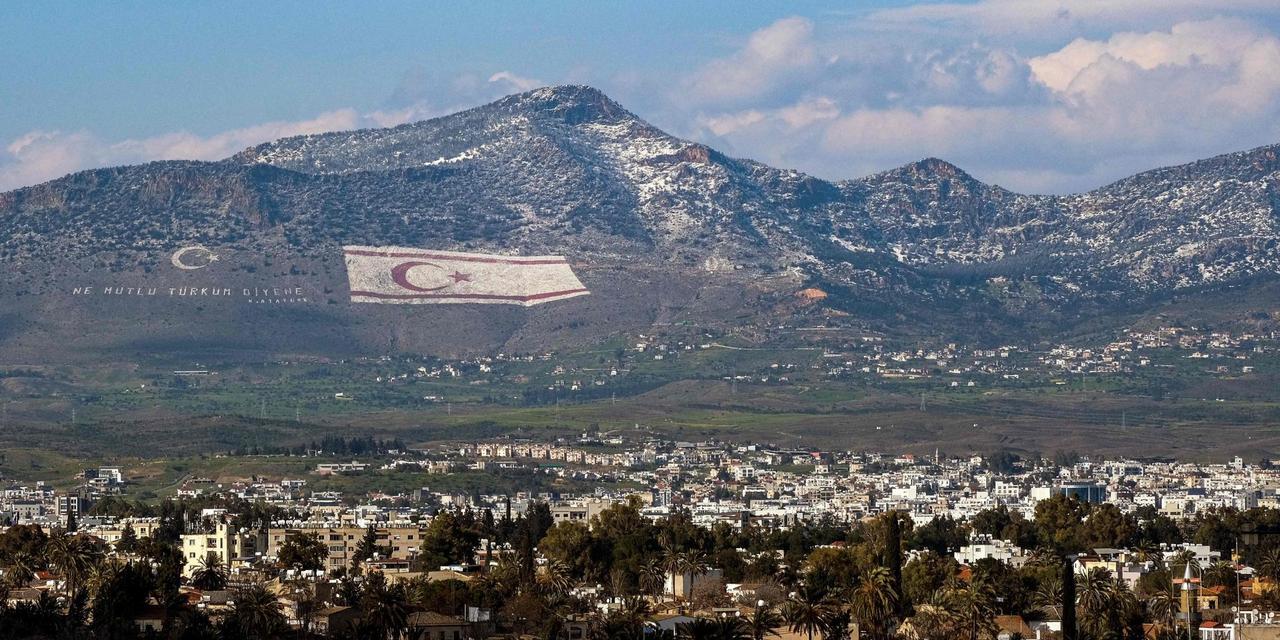 A view of snow covering a portion of Cyprus' northern Girne mountain range, above the flag of the Turkish Cyprus (TRNC), Lefkosia, on March 13, 2022. (AFP Photo)