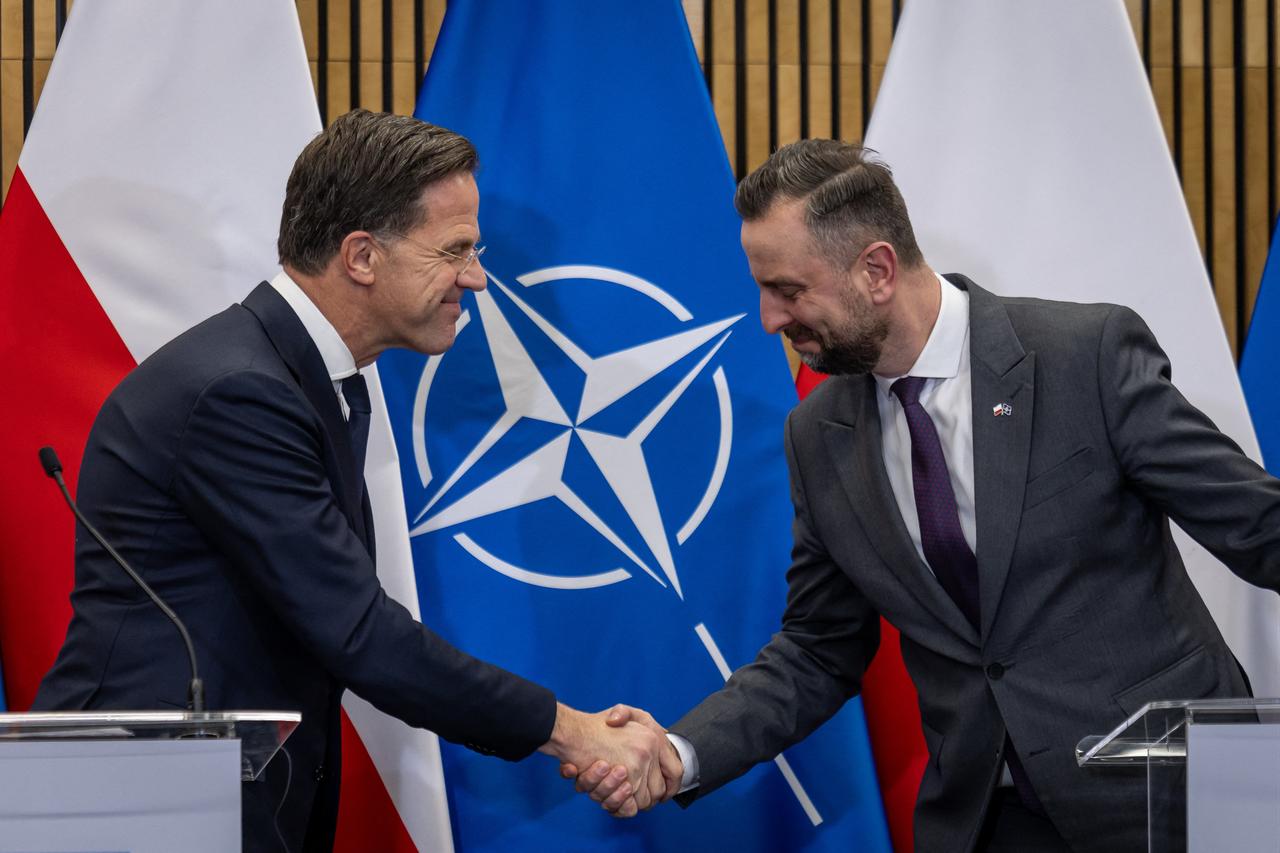 NATO Secretary General Mark Rutte (L) and Poland's Deputy Prime Minister and Defence minister Wladyslaw Kosiniak-Kamysz (R) shake hands during a joint press conference after their meeting at the Land Forces Training Center in Bemowo Piskie, Poland on Dec. 18, 2025. (AFP Photo)