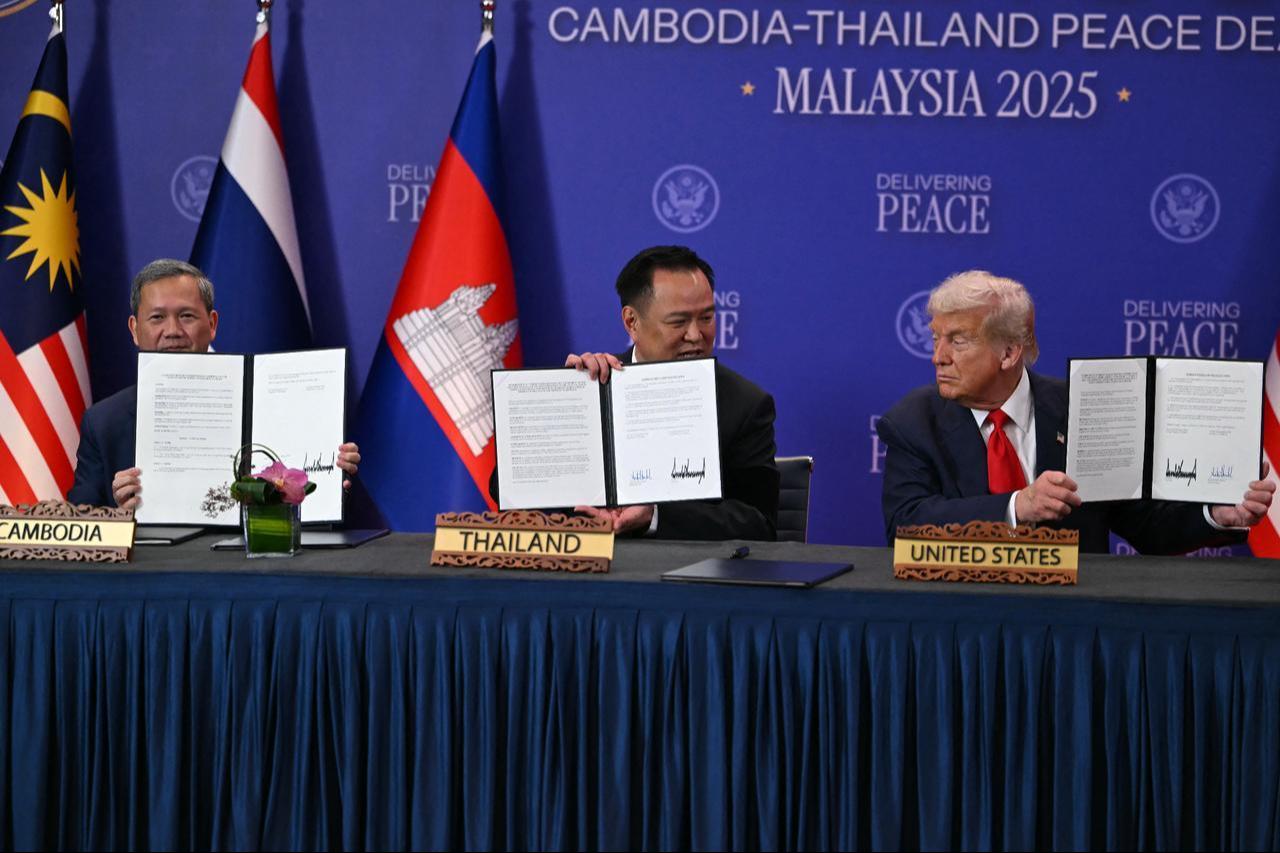 U.S. President Donald Trump (R) holds up a signed document with Cambodias Prime Minister Hun Manet (L) and Thailands Prime Minister Anutin Charnvirakul (C) during the ceremonial signing of a ceasefire agreement on the sidelines of the 47th Association of Southeast Asian Nations (ASEAN) Summit in Kuala Lumpur on Oct. 26, 2025. (AFP Photo)