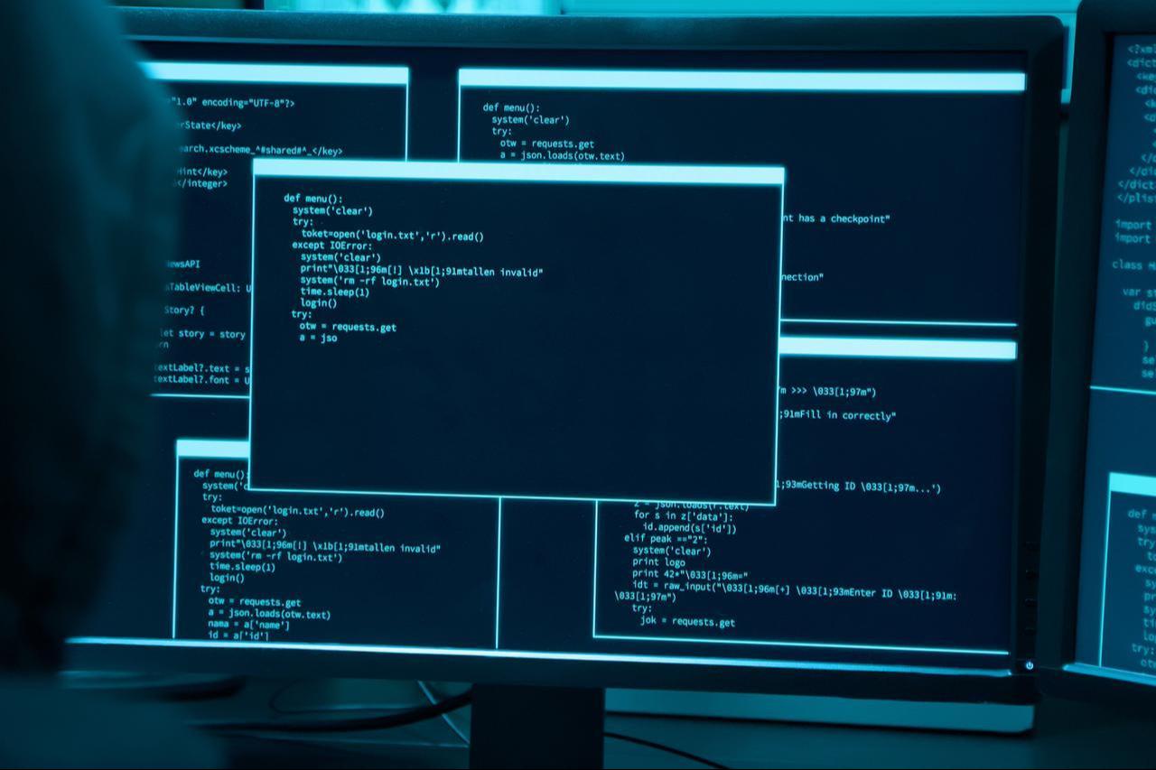 Back view of a person, illustrated as a hacker, using a computer. (Adobe Stock Photo)