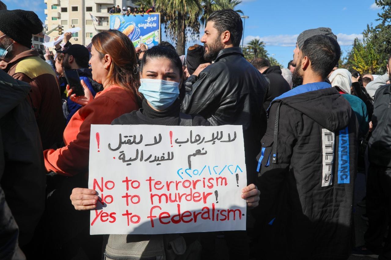 Demonstrators hold placards targeting central government during a demonstrations demanding federalism held in Latakia, Syria on December 28, 2025.  (Anadolu Agency photo)