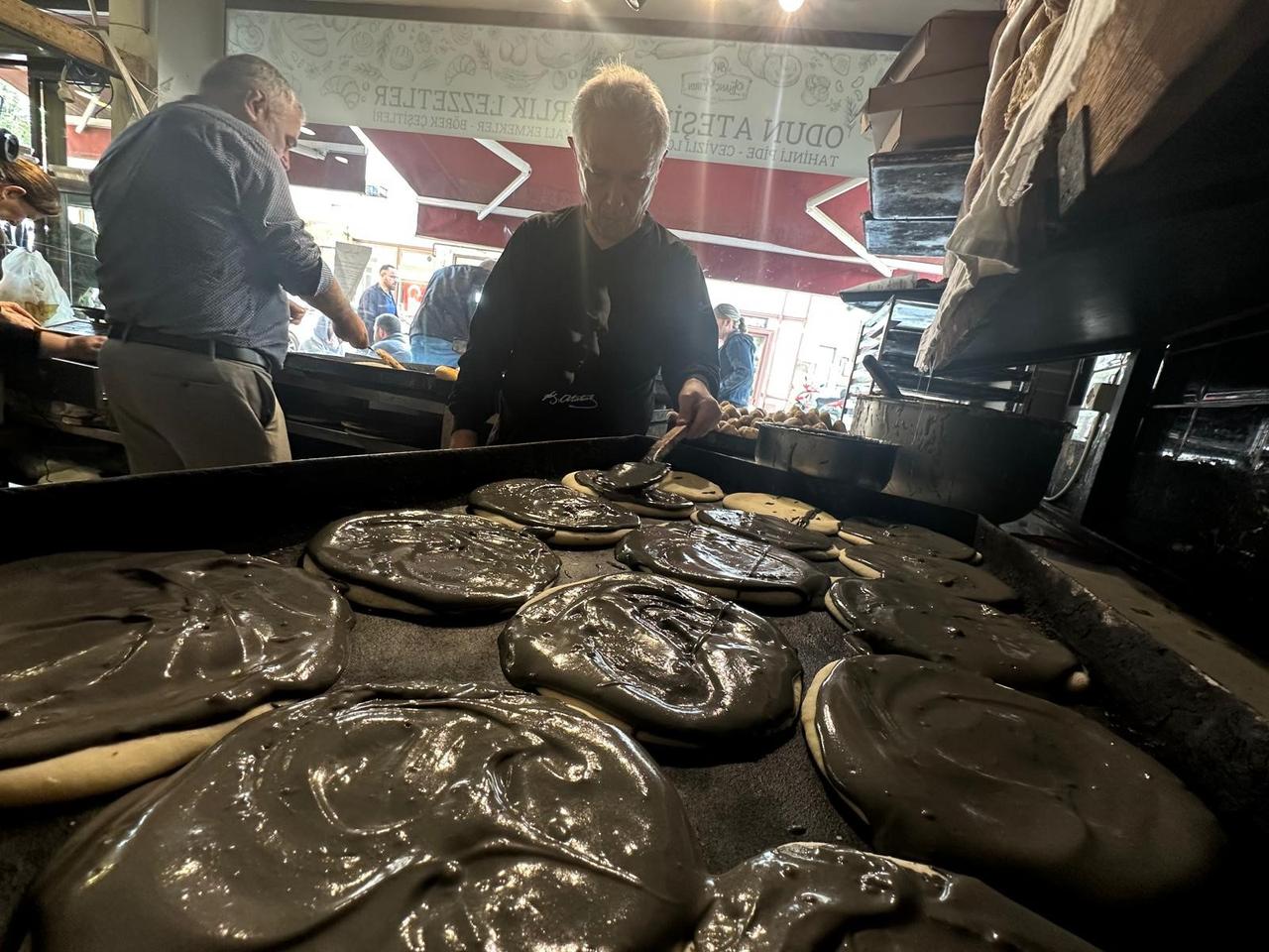 Bakery workers prepare traditional “Bursa tahinli pidesi” using black sesame tahini at the century-old shop in Bursa, Türkiye, Dec. 2, 2025. (IHA Photo)
