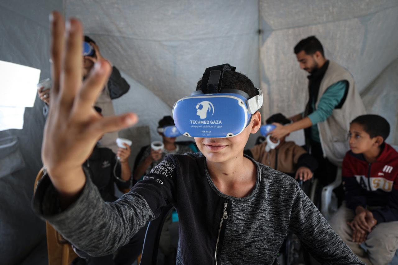Palestinian children wearing goggles and holding a joystick experience virtual reality as a medical technology support team launches an initiative in the city of Al-Zawayda, in the central Gaza Strip, on November 30, 2025. (AFP Photo)
