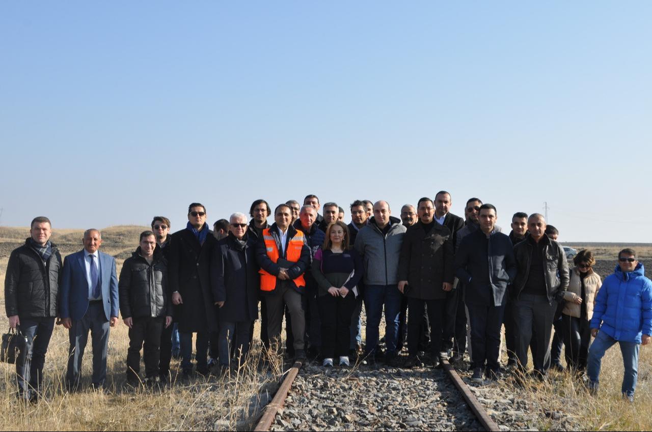 Turkish and Armenian officials pose for a photo on the disused Kars–Gyumri railway line during a bilateral visit to assess the route's rehabilitation and reopening, Kars, Türkiye, November 28, 2025. (AA Photo)