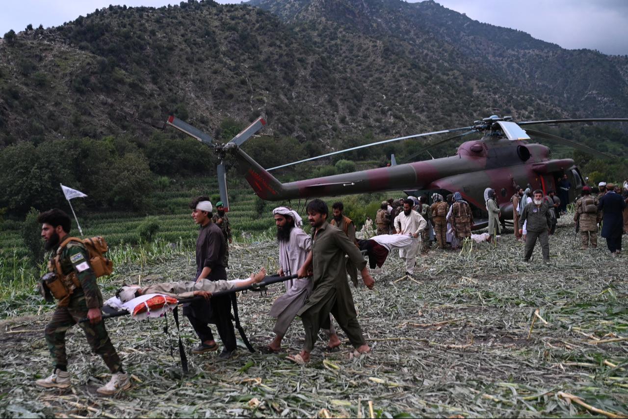 Afghan volunteers and Taliban security personnel work to move injured people near a military helicopter following earthquakes in the Mazar Dara village of Nurgal, a district of the Kunar Province, in Eastern Afghanistan, September 1, 2025. (AFP Photo)