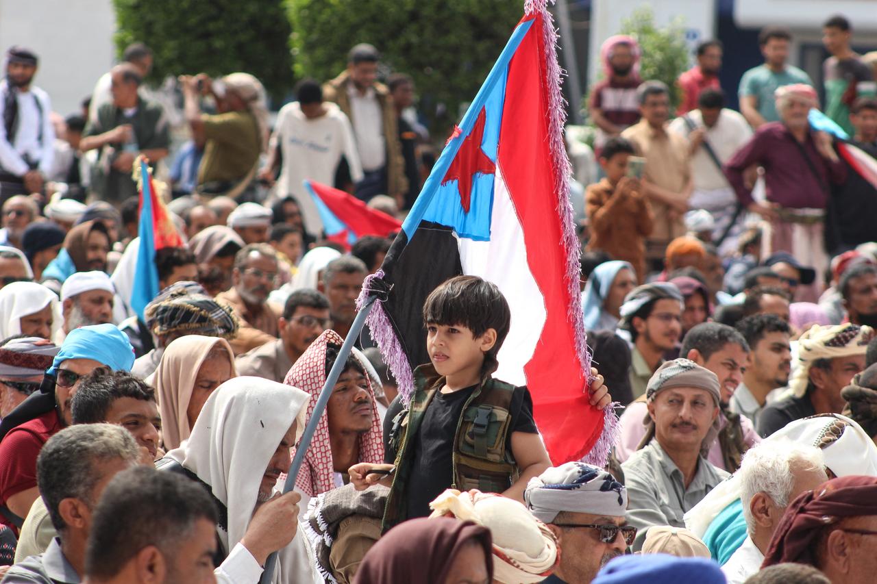 A boy looks on as supporters of the Southern Transitional Council (STC), a coalition of separatist groups seeking to restore the state of South Yemen, hold South Yemen flags during a rally calling for the revival of the former independent state, in Aden on Dec. 12, 2025. (AFP File Photo)
