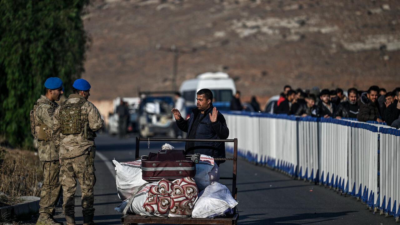 A Syrian refugee gestures as she speaks with Turkish soldiers at Cilvegozu cross-border gate before entering Syria at Reyhanli district in Hatay, Dec. 9, 2024. (AFP Photo)