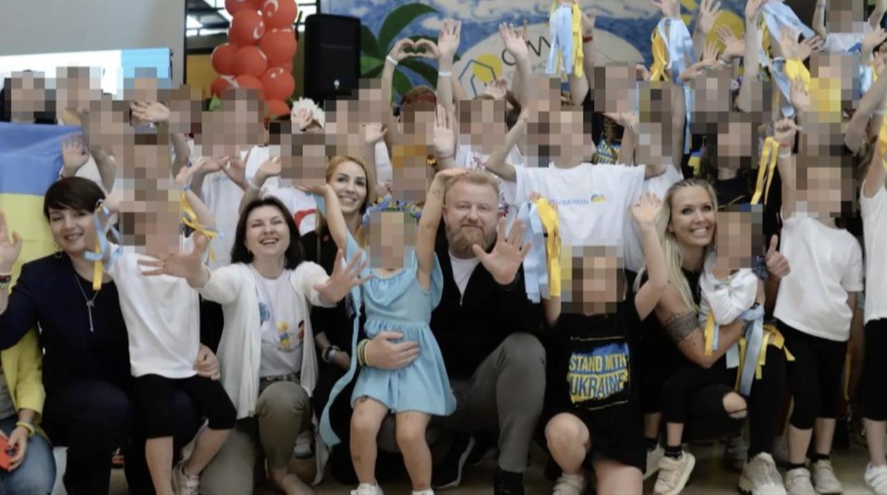 Ruslan Shostak surrounded by children in a promotional photograph. (Photo via Facebook)