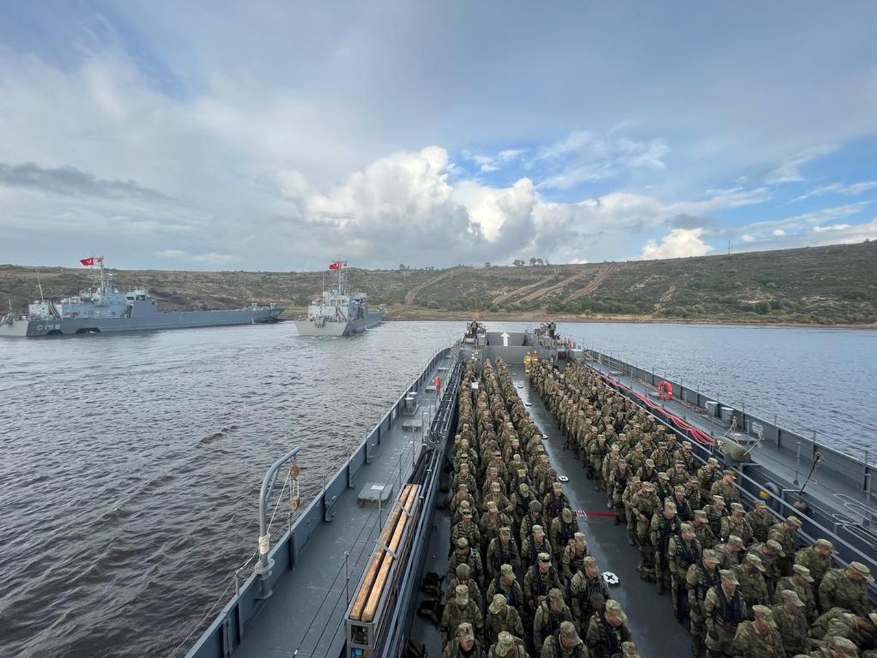 The image depicts Turkish military personnel and naval vessels during an amphibious military exercise. (Photo via X/ @tcsavunma)