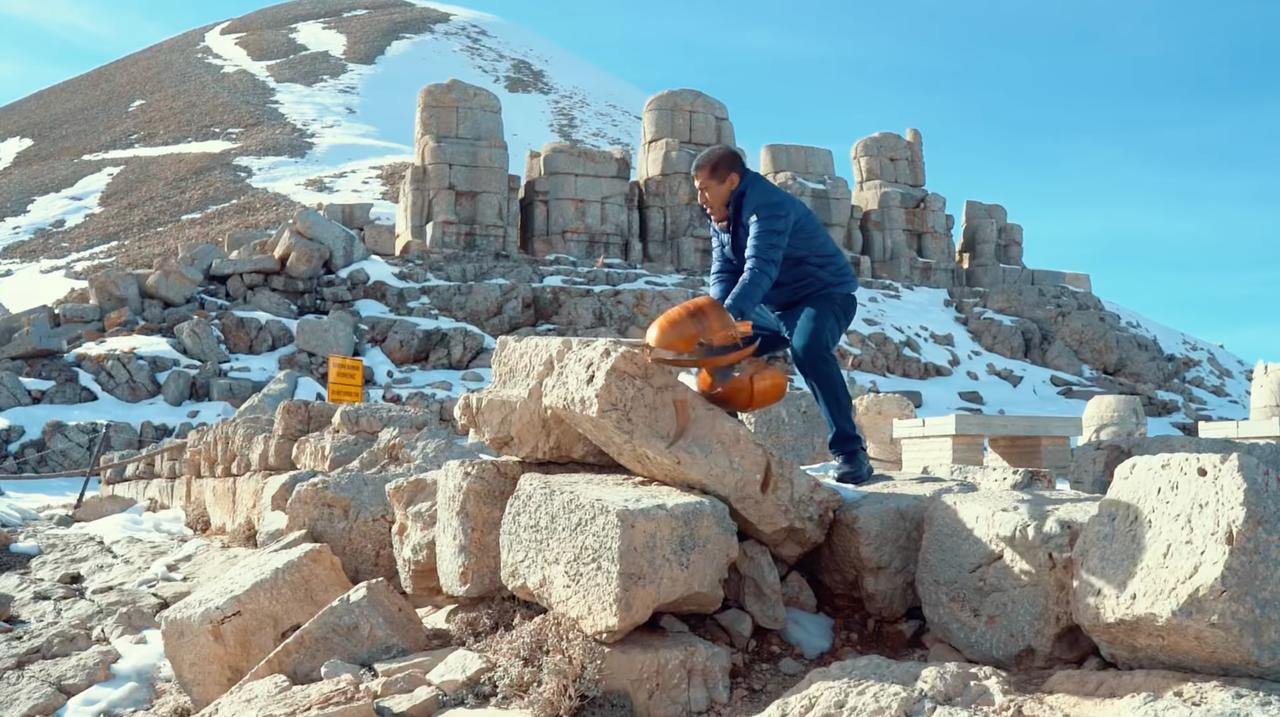 Turkish singer Aydin Aydin hits his saz against the 2,100 year old Kommagene remains during his filmed protest at Mount Nemrut, Adiyaman, Türkiye, November 21, 2025. (Photo via YouTube)