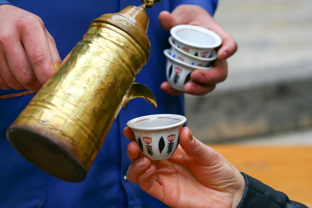 Freshly brewed mirra coffee being poured into small cups during a street-serving ritual in Sanliurfa, Türkiye. (Adobe Stock Photo)